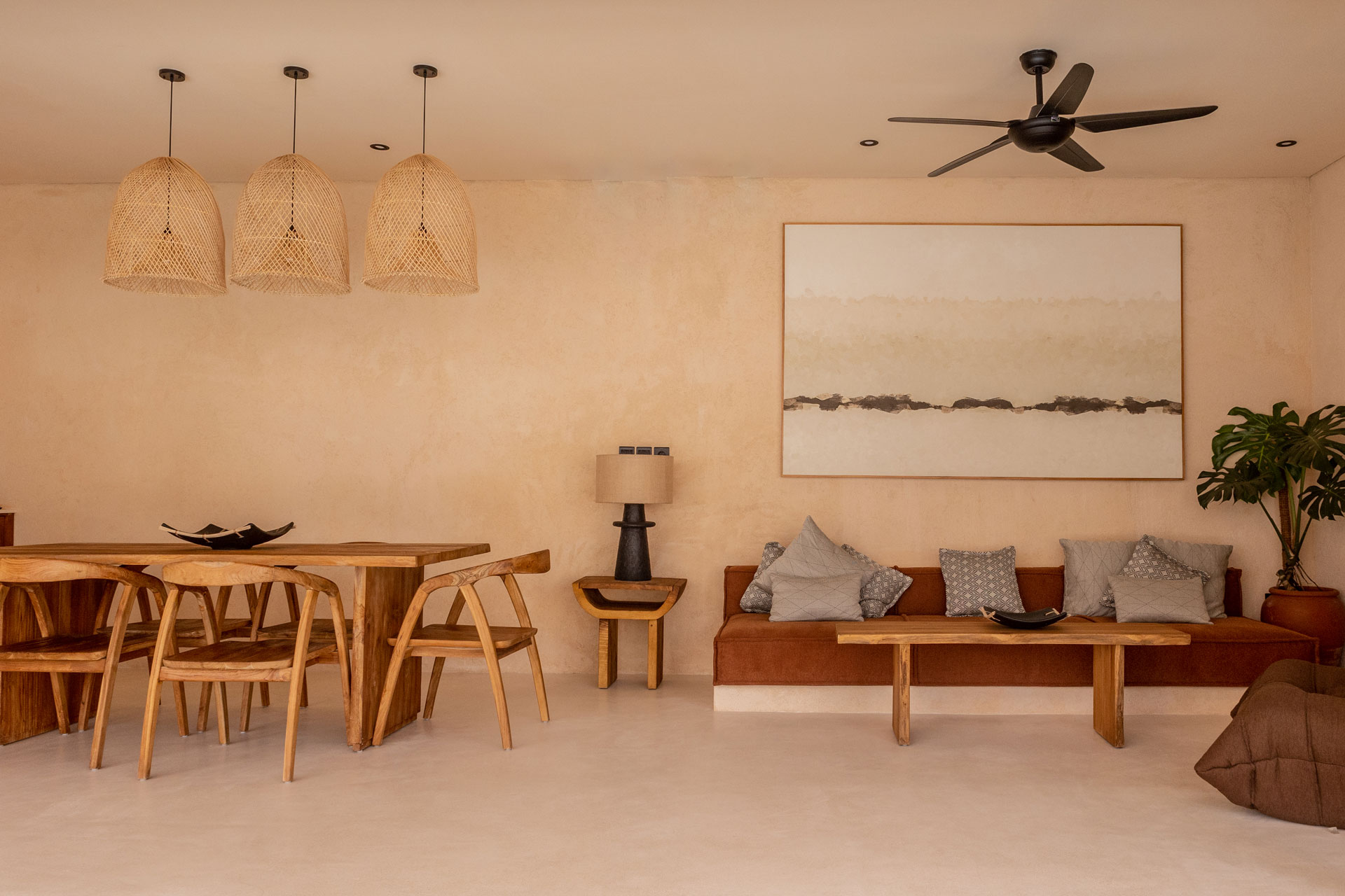 Open-plan villa living and dining space with rattan pendants, designed by Paz Studio Bali