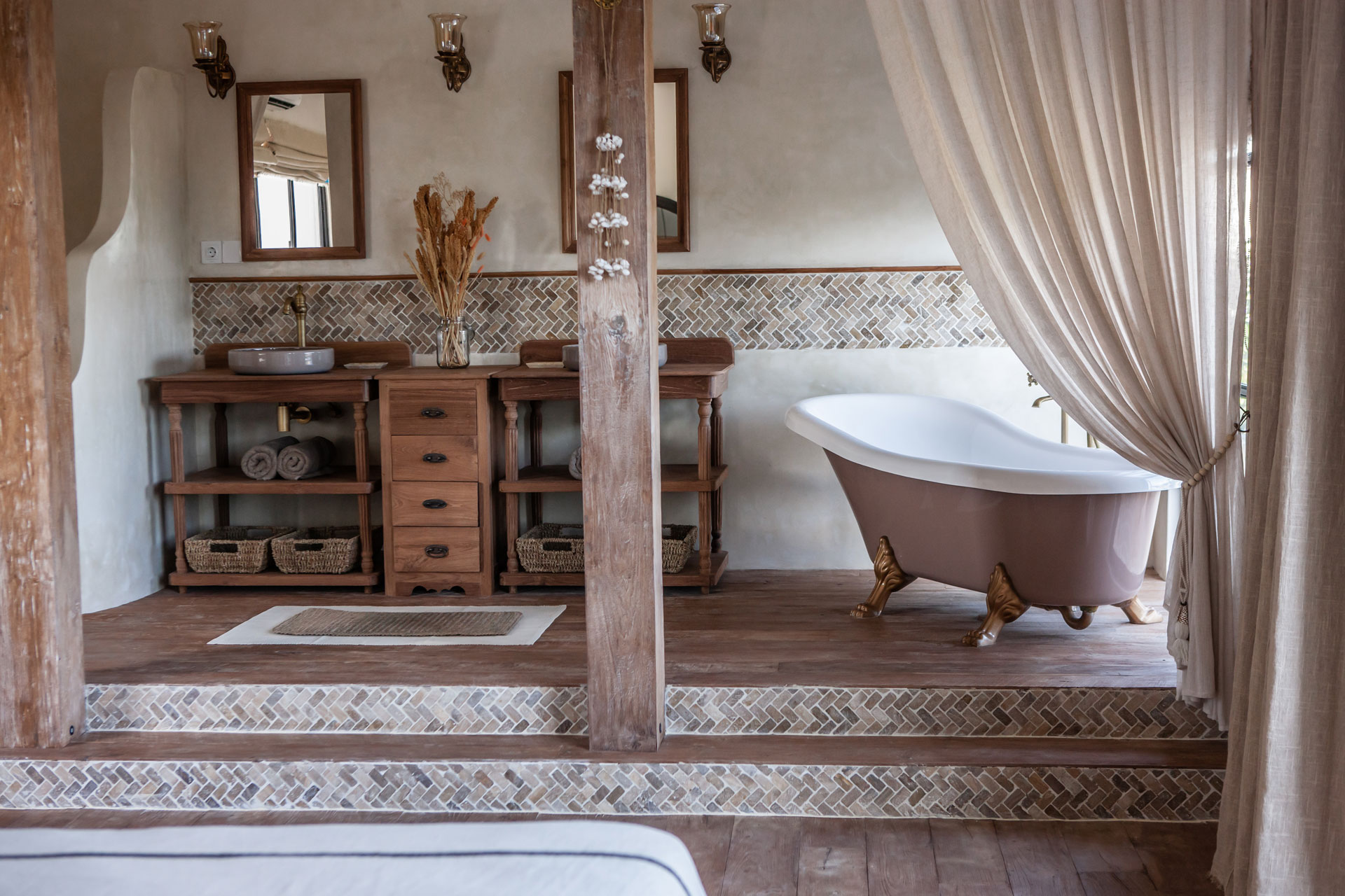 Villa bathroom with a freestanding bathtub and rustic timber vanity, designed by Paz Studio Bali
